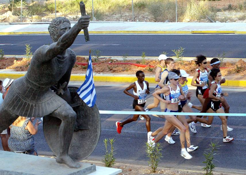 Passaggio di consegne: un gruppetto di atlete in corsa alla maratona femminile, vinta dalla giapponese Mizuki Noguchi in 2:26.32, ritratte accanto ad un’antica statua greca. AFP